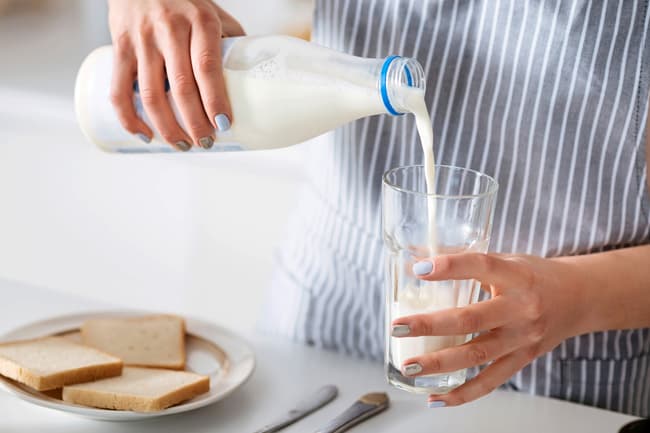 photo of man pouring glass of milk