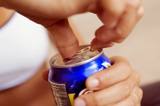 photo of woman opening soda can