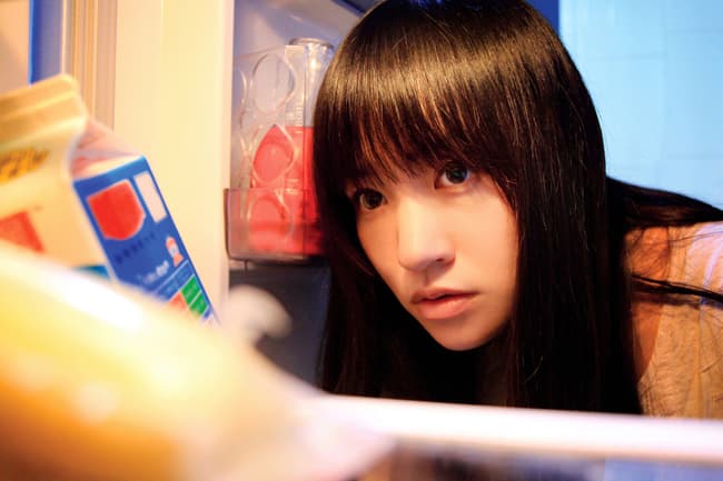 young woman looking in refrigerator